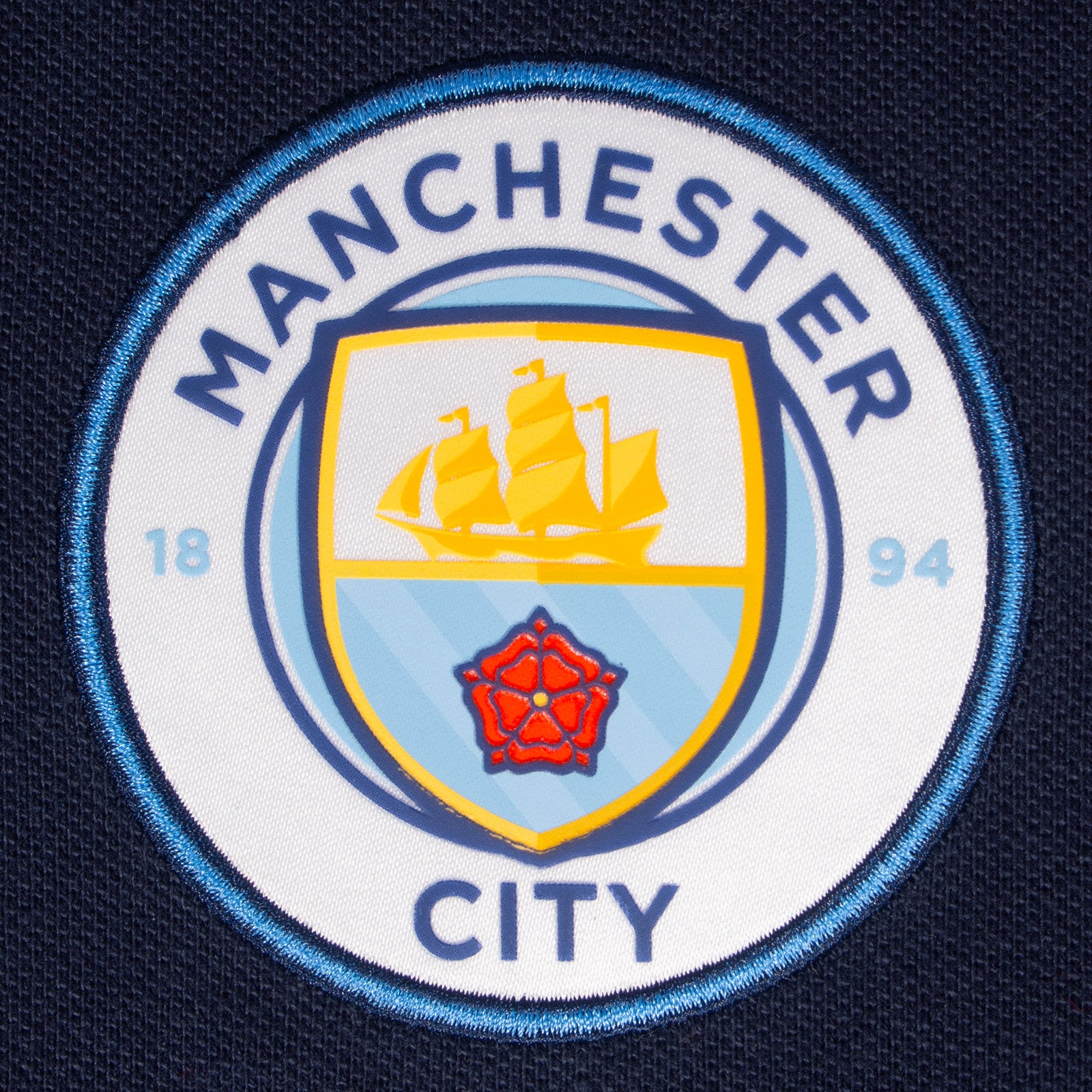 Man City adults polo shirt in navy blue with contrast sleeve and club crest to the chest.