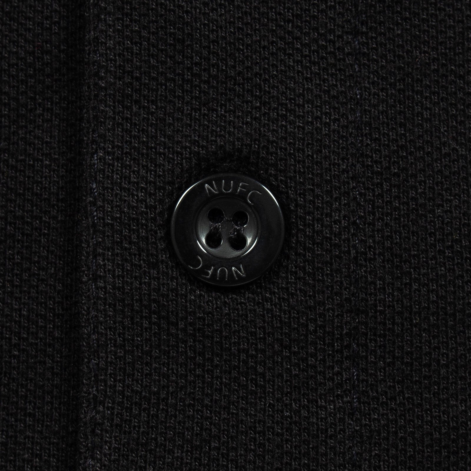 Newcastle Utd adults polo shirt in black with contrast sleeve and a NUFC badge and text to chest.