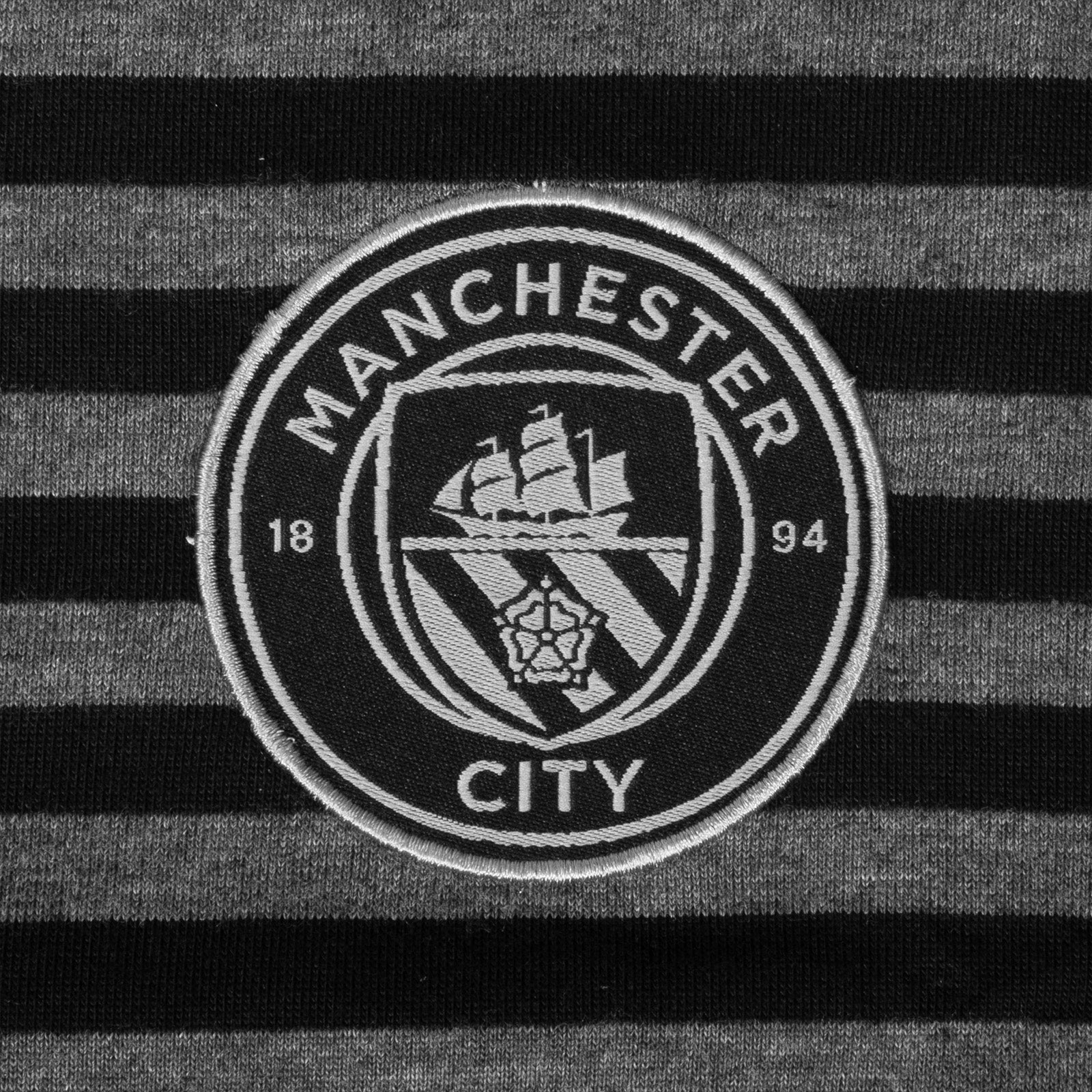 Man City long sleeve polo shirt for kids in black & grey with club crest to chest.