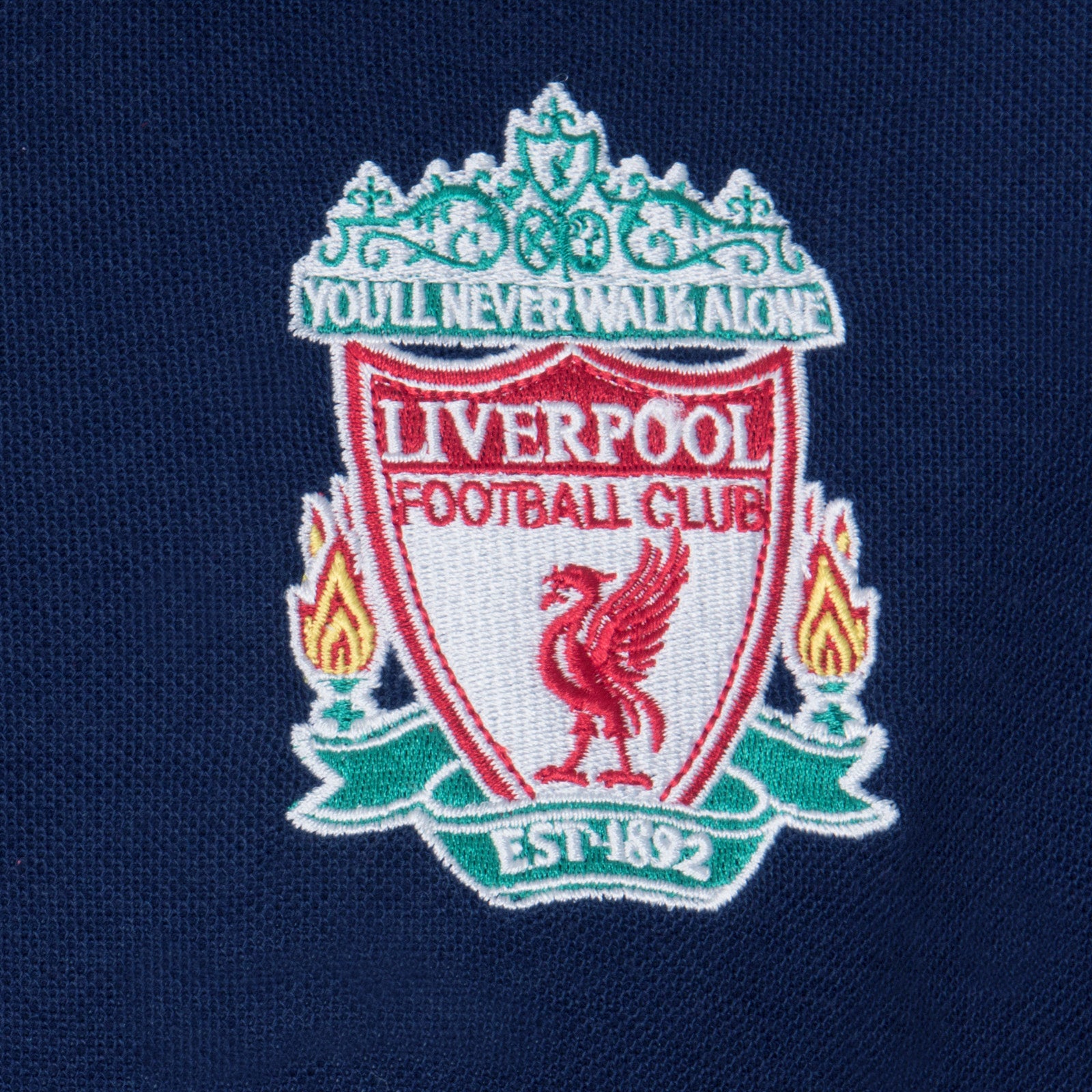 Liverpool kids polo shirt in navy blue with LFC badge and Liverpool FC text to chest.