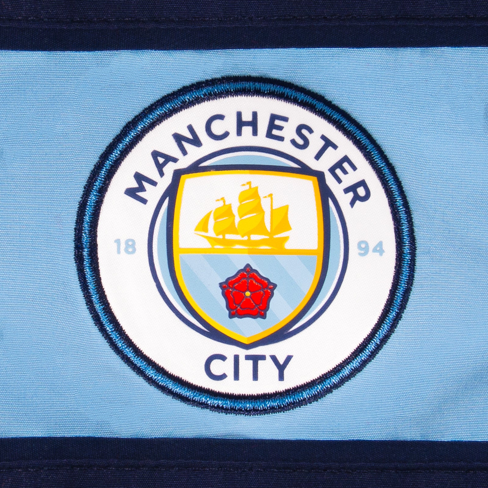Man City kids tracksuit in navy & sky blue with club crest to chest and left thigh