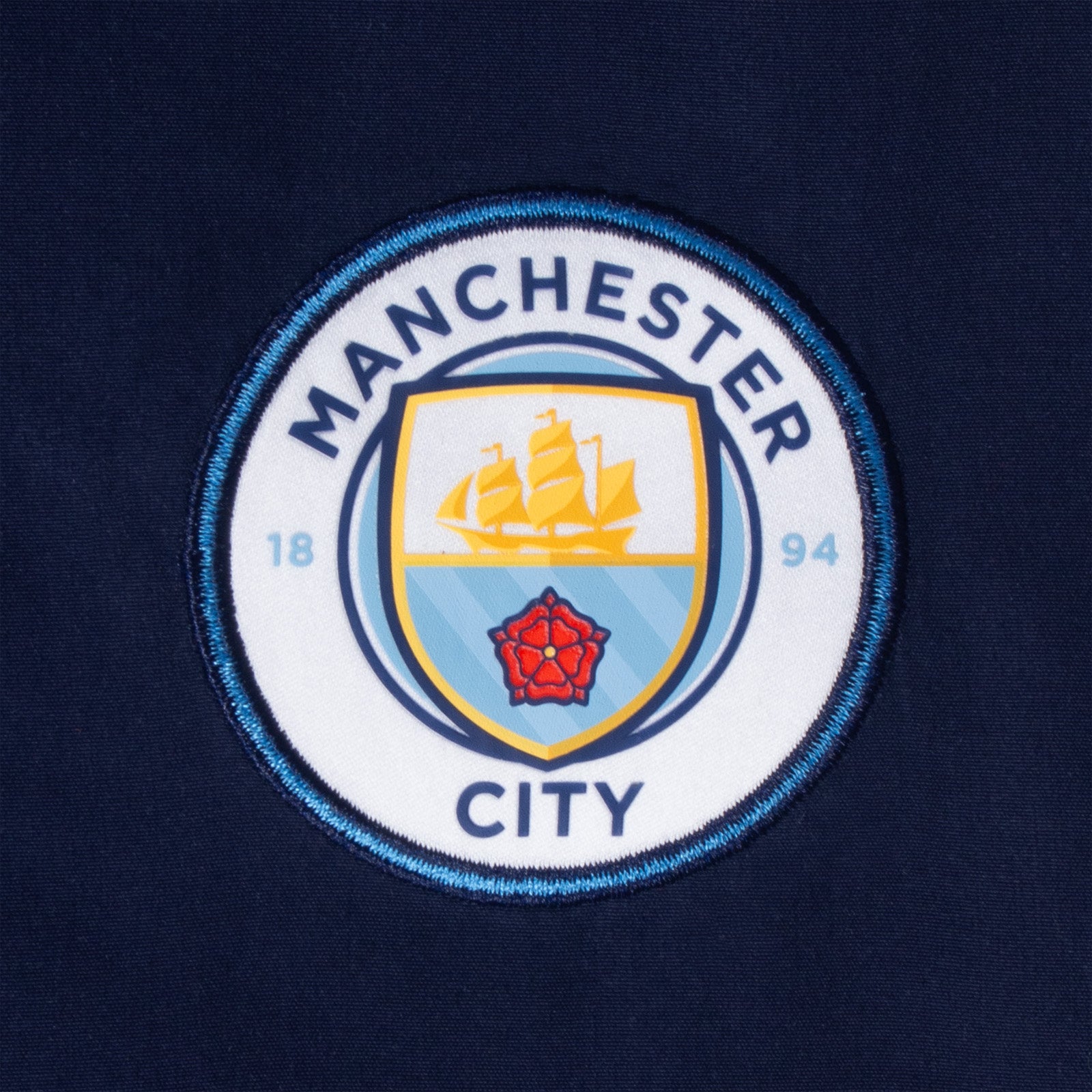 Man City kids tracksuit in navy & sky blue with club crest to chest and left thigh