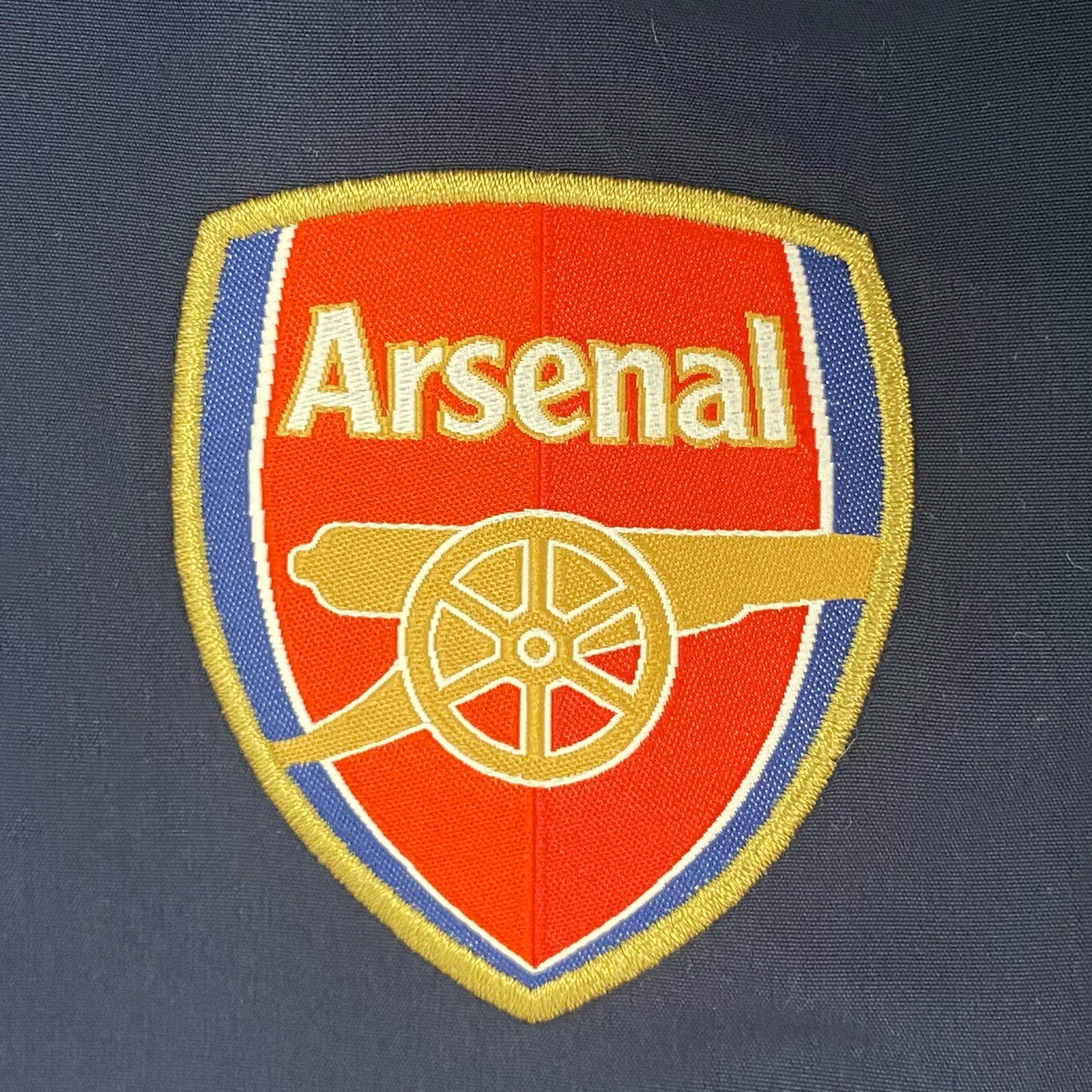 Arsenal adults tracksuit in navy blue & red with club crest to chest and left thigh