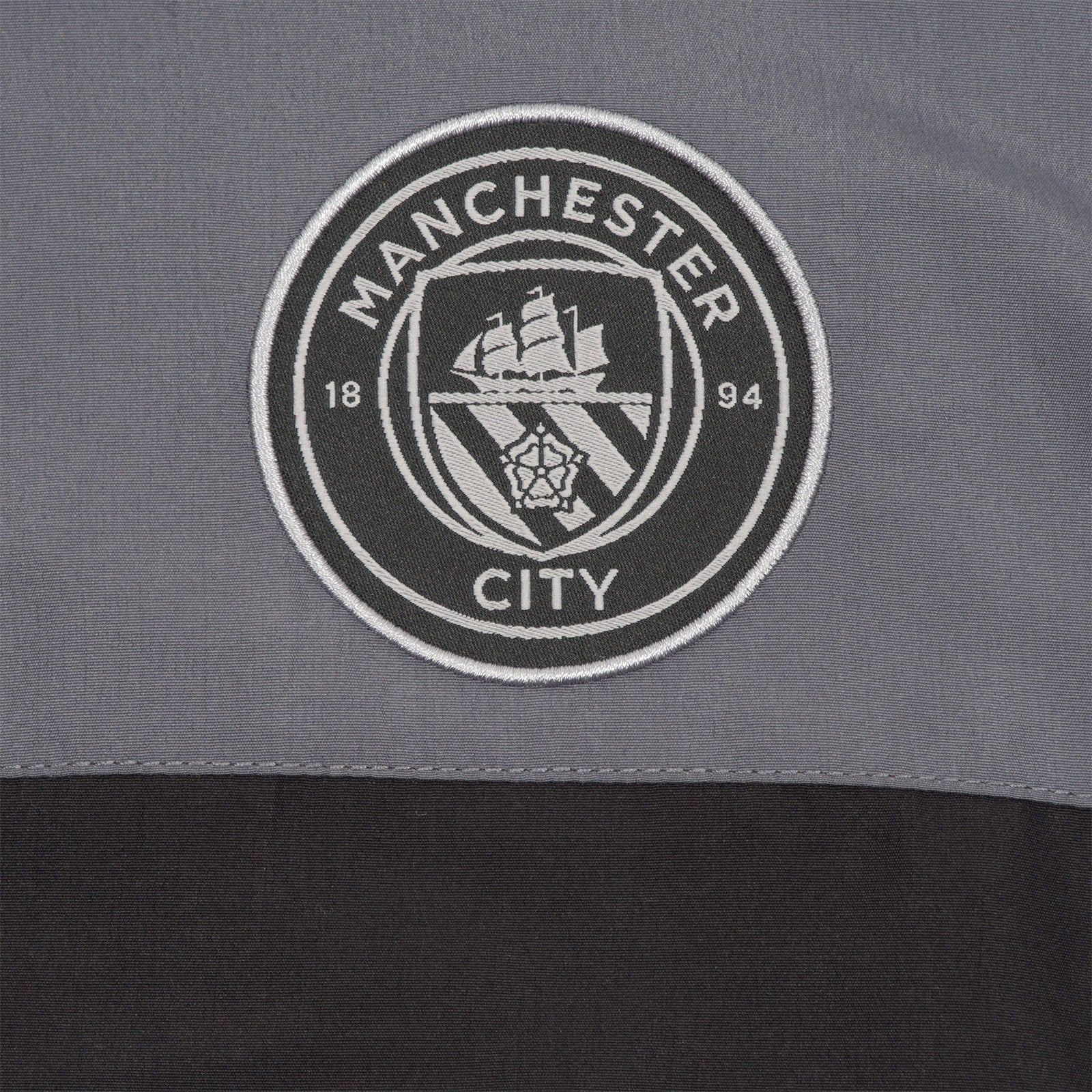 Man City adults tracksuit in grey with club crest to chest and left thigh