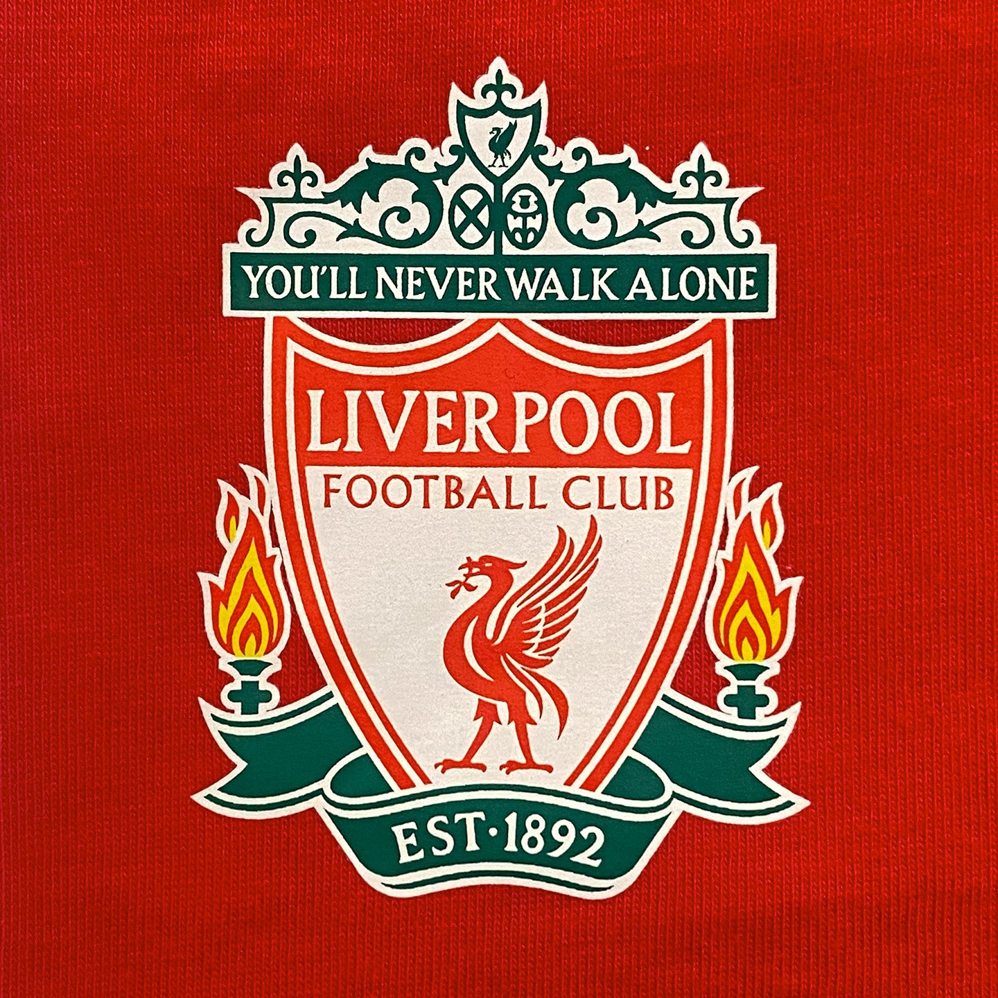 Liverpool kids pyjamas in red. Short sleeve top with graphic and shorts with logo to the left leg