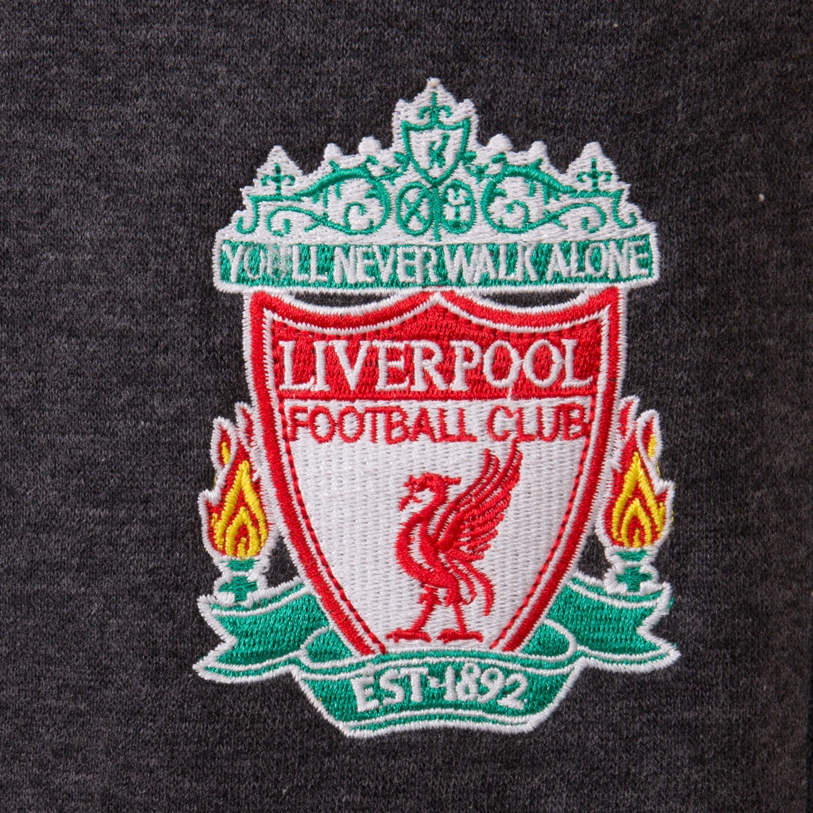 Liverpool kids slim fit track pants in charcoal grey with club crest and text to left leg.