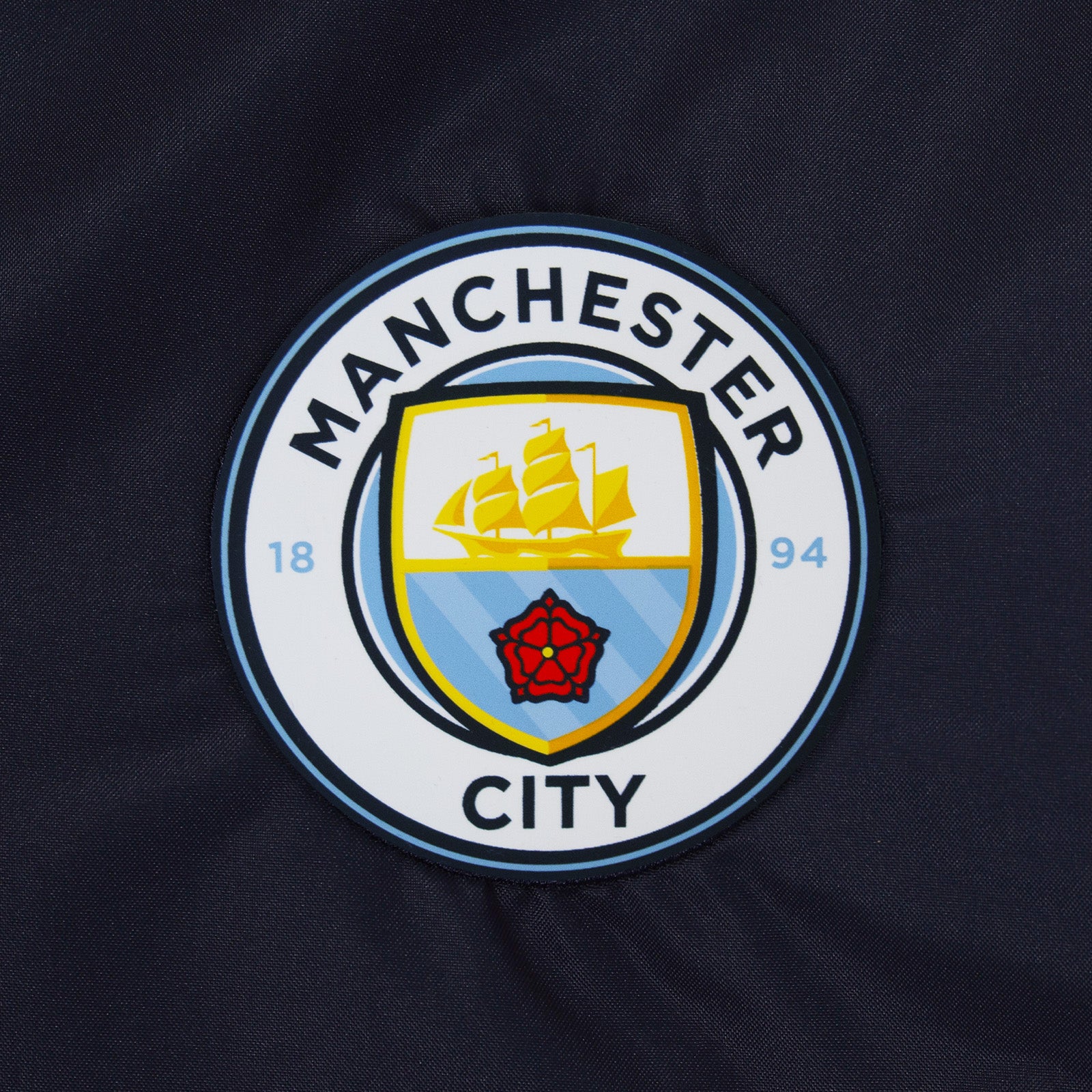 Man City adults shower jacket with hood in navy blue with club crest to chest.