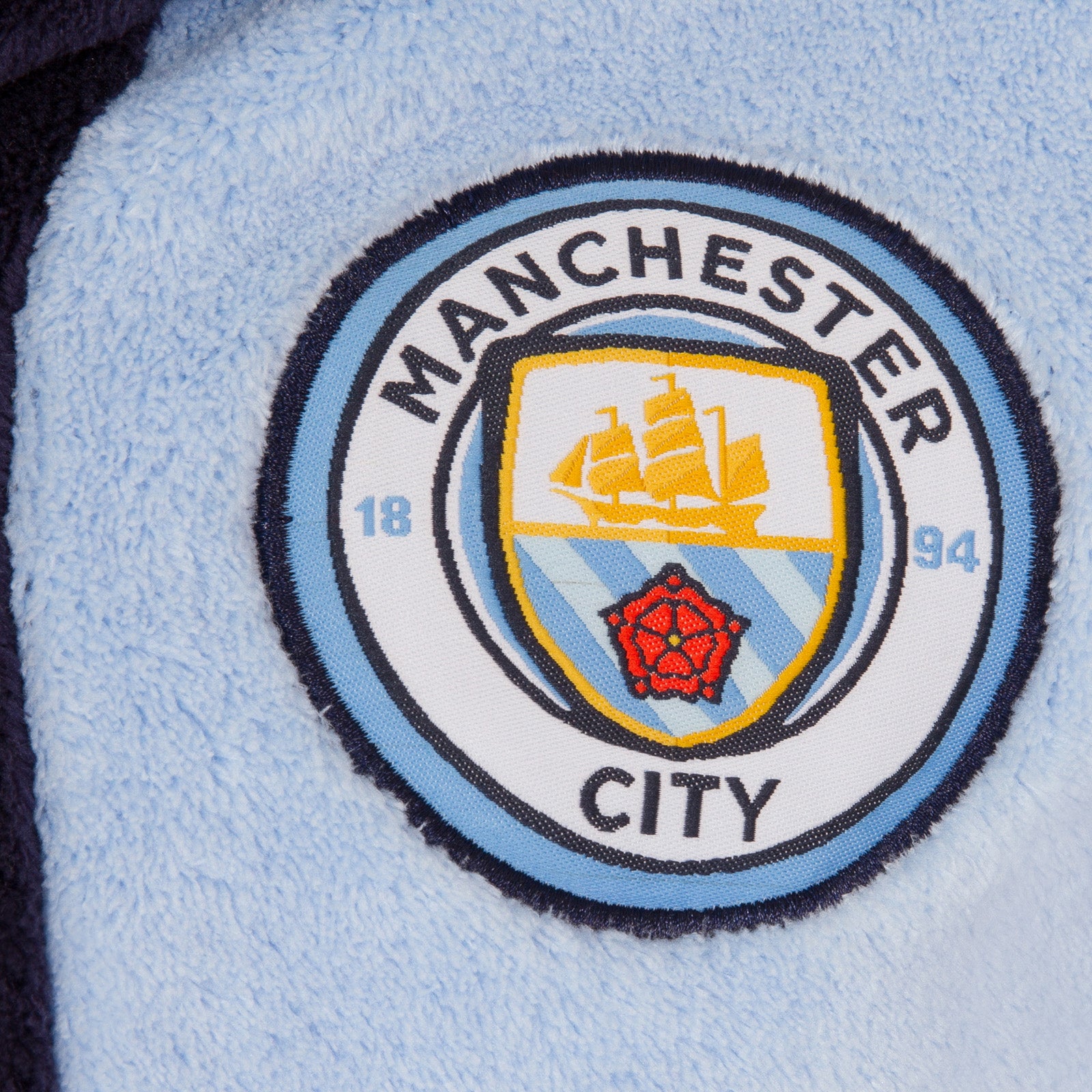 Man City kids hooded dressing gown in sky blue with crest.