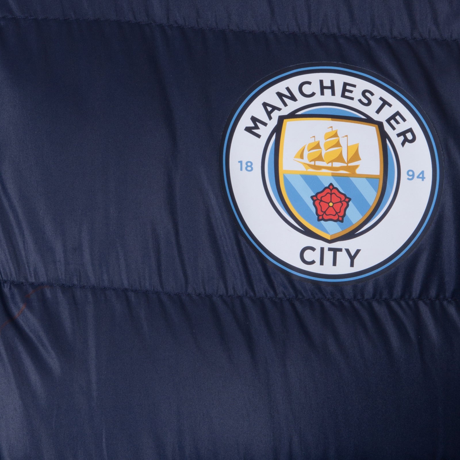 Man City kids quilted jacket in navy blue with club crest to chest.