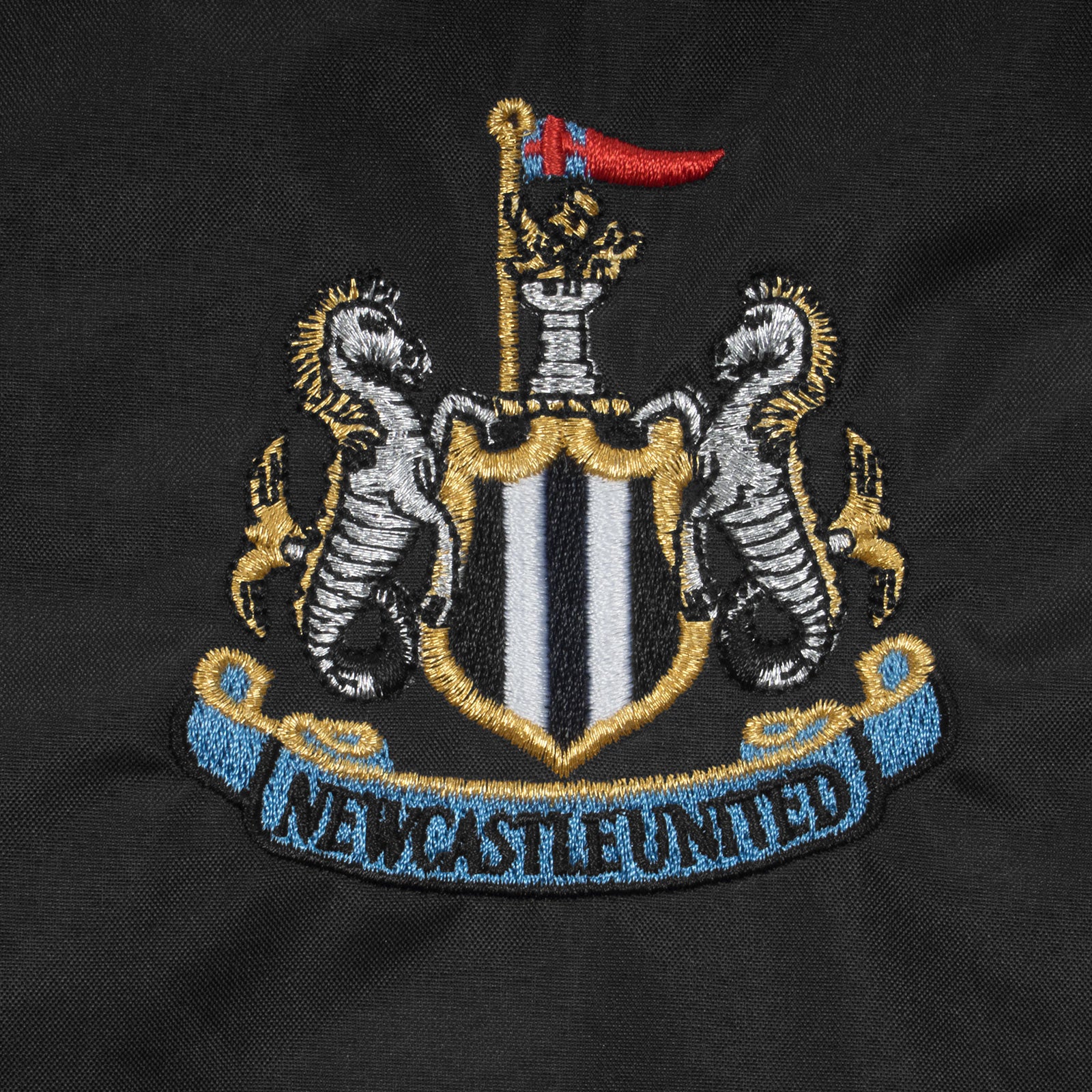 Newcastle Utd adults hooded shower jacket in black with club crest to chest .