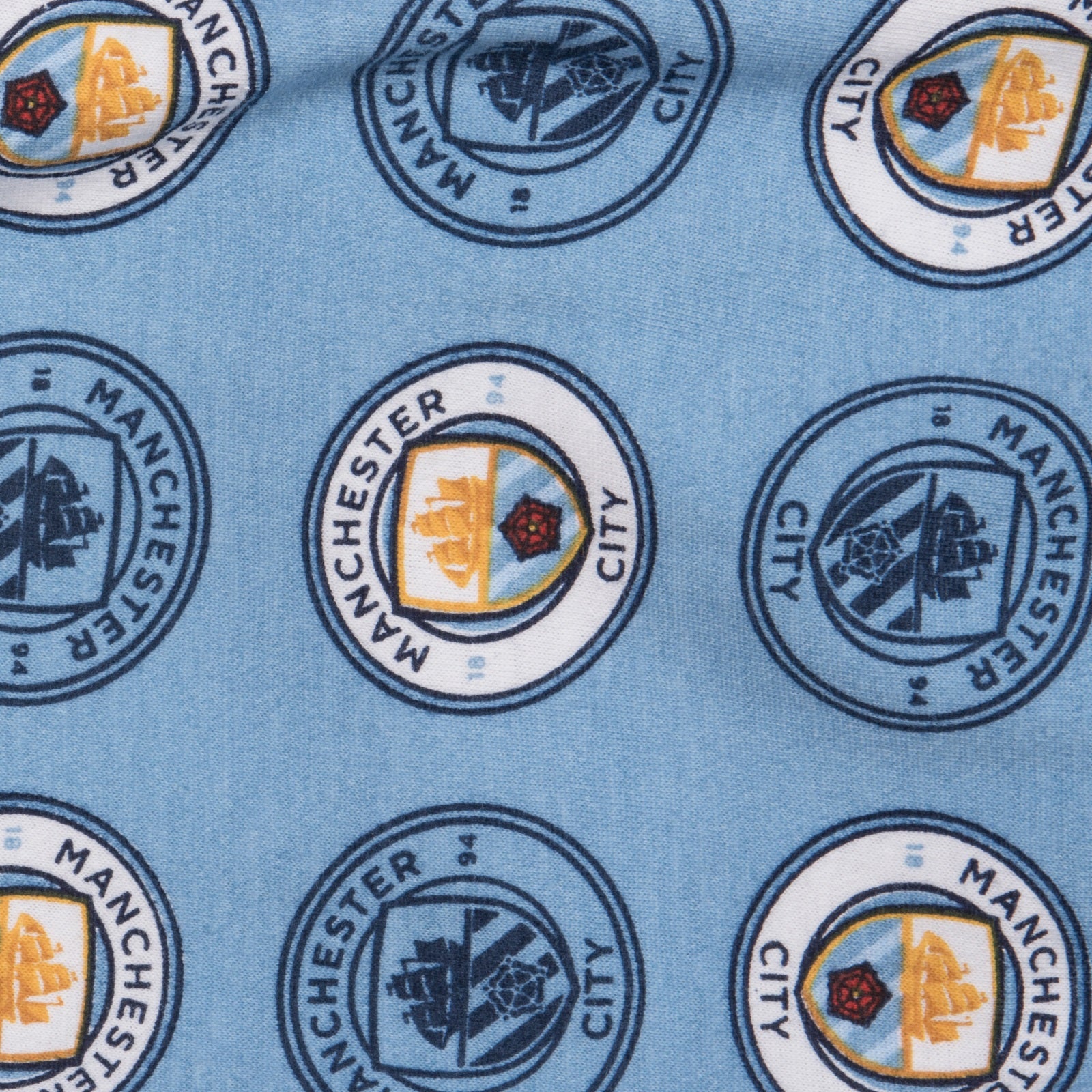 Man City baby pyjamas in sky blue. Long sleeve top with club crest & text print. Matching bottoms with all over crest print