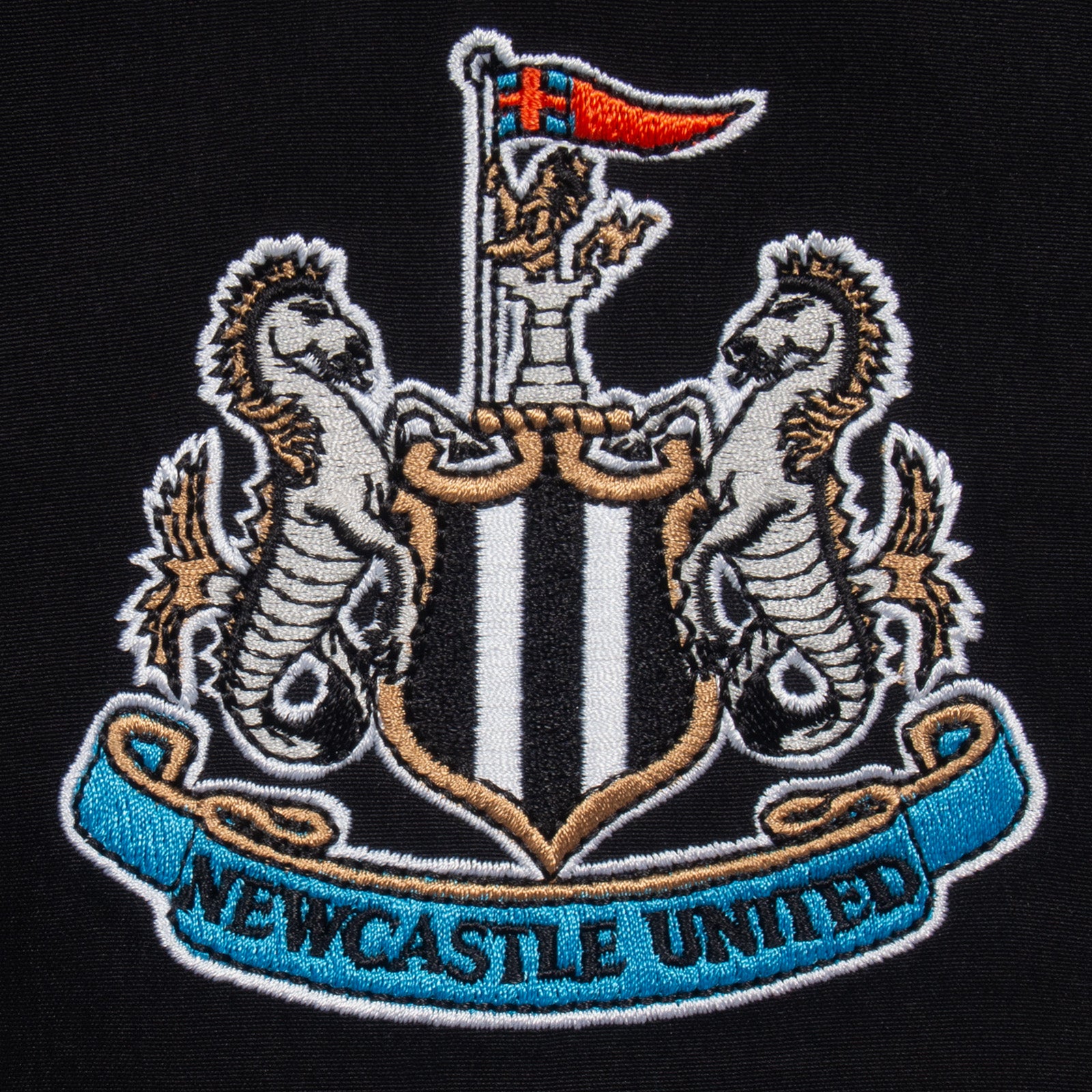 Newcastle Utd kids tracksuit in black with club crest to chest and left thigh