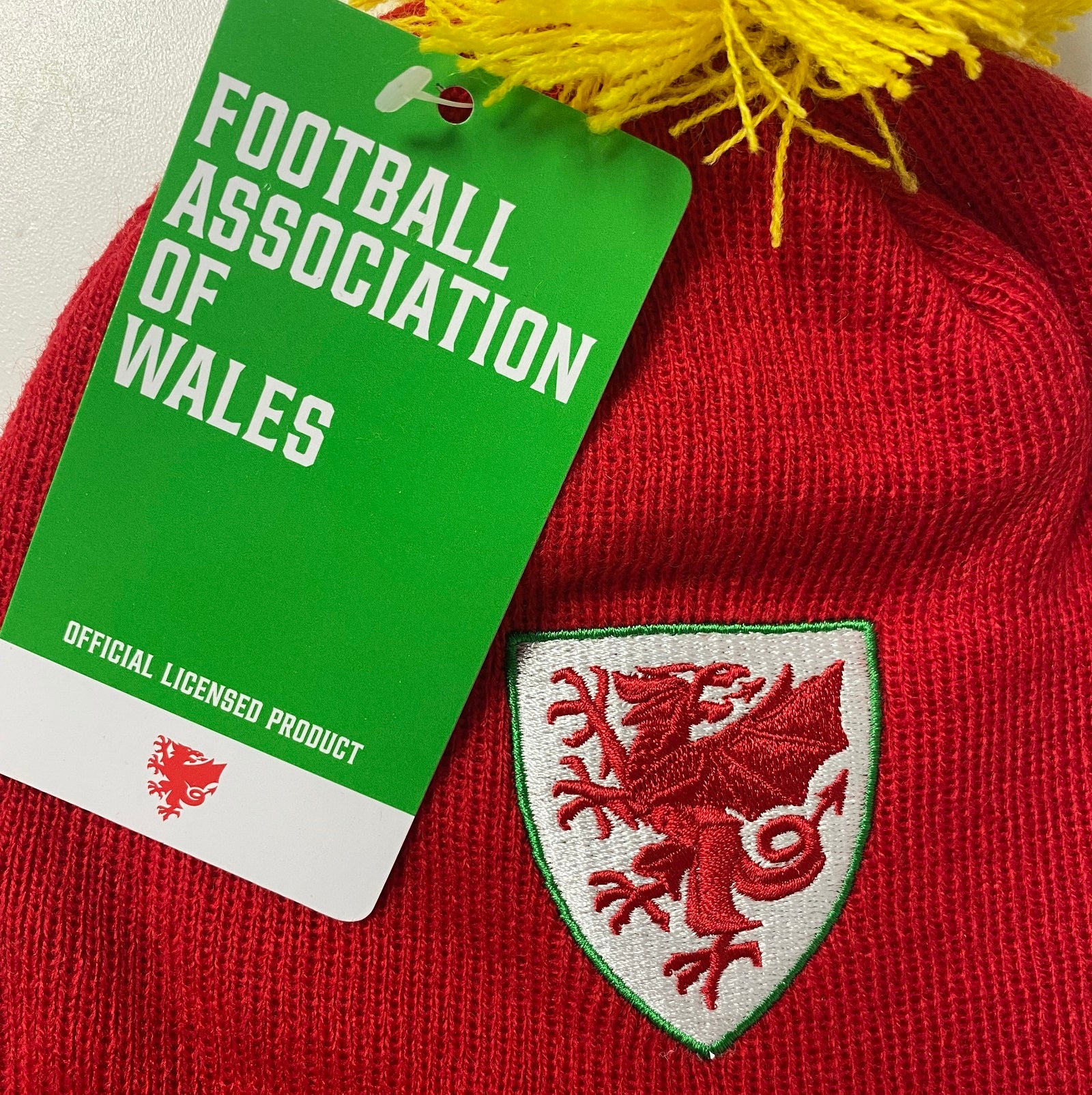 Wales bar scarf & bobble hat in red, yellow & green with Wales crest to hat & to end of the scarf.
