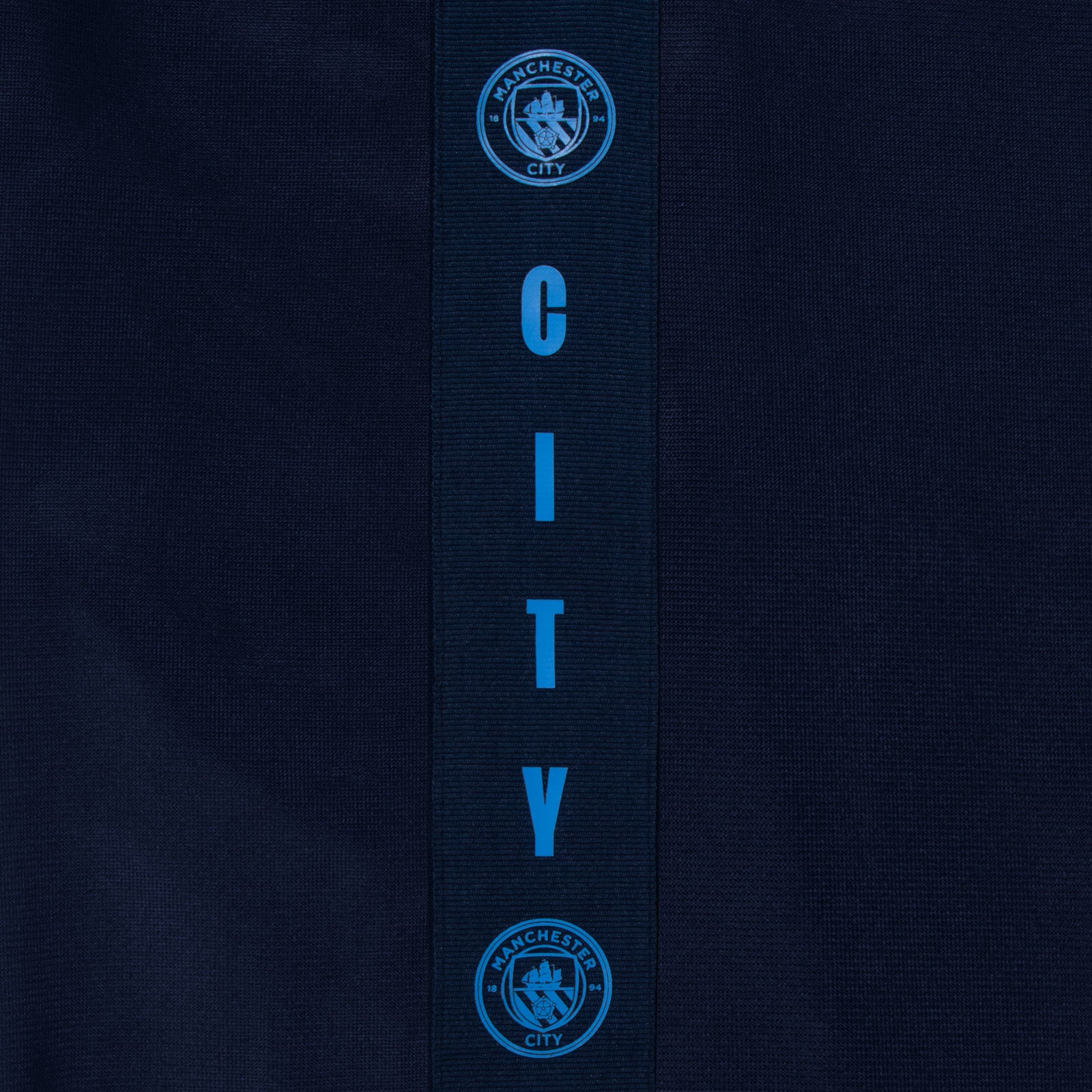 Manchester City kids taped tracksuit in navy blue with club crest and text to both top & pants