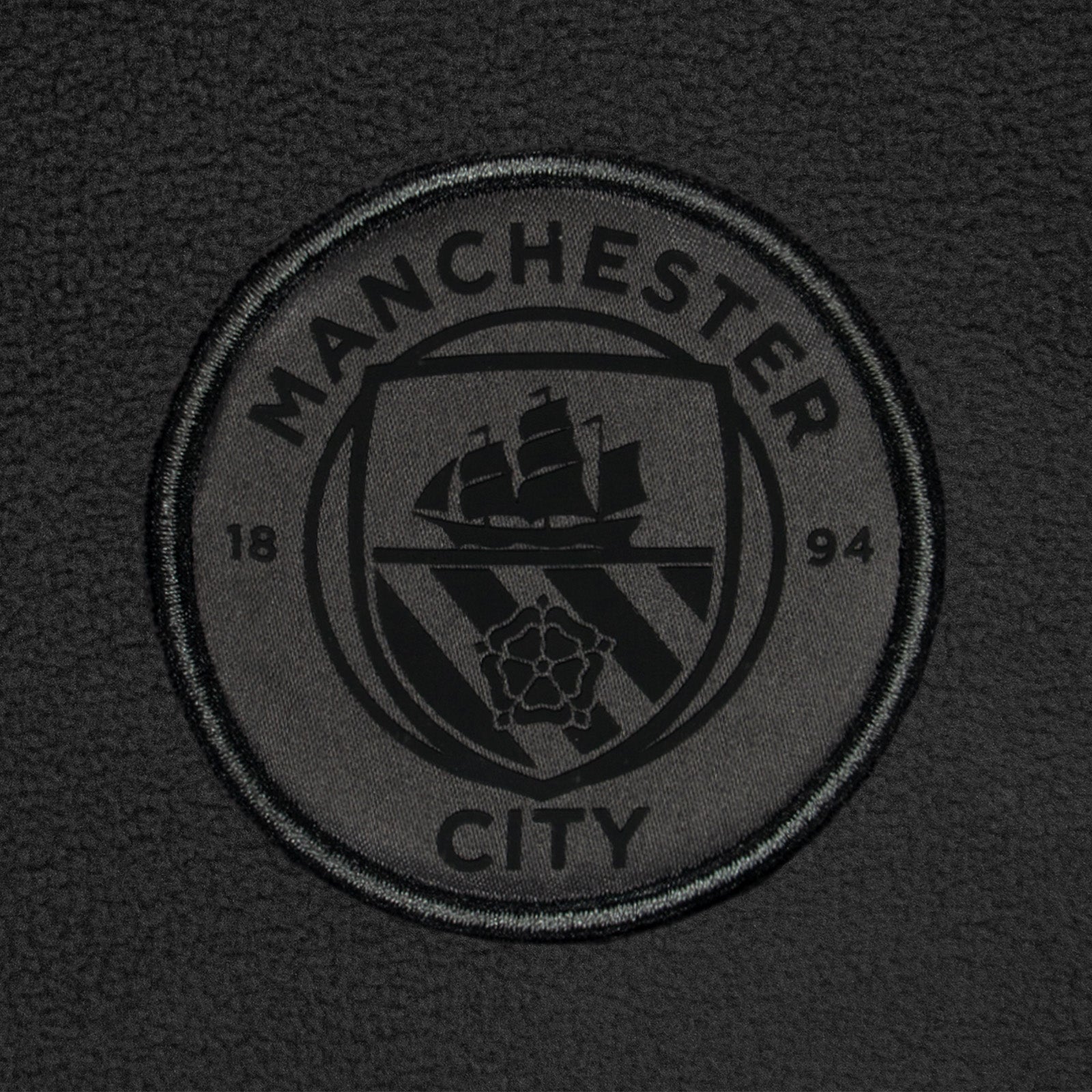 Manchester City adults microfleece jacket in grey with a woven club crest to chest.