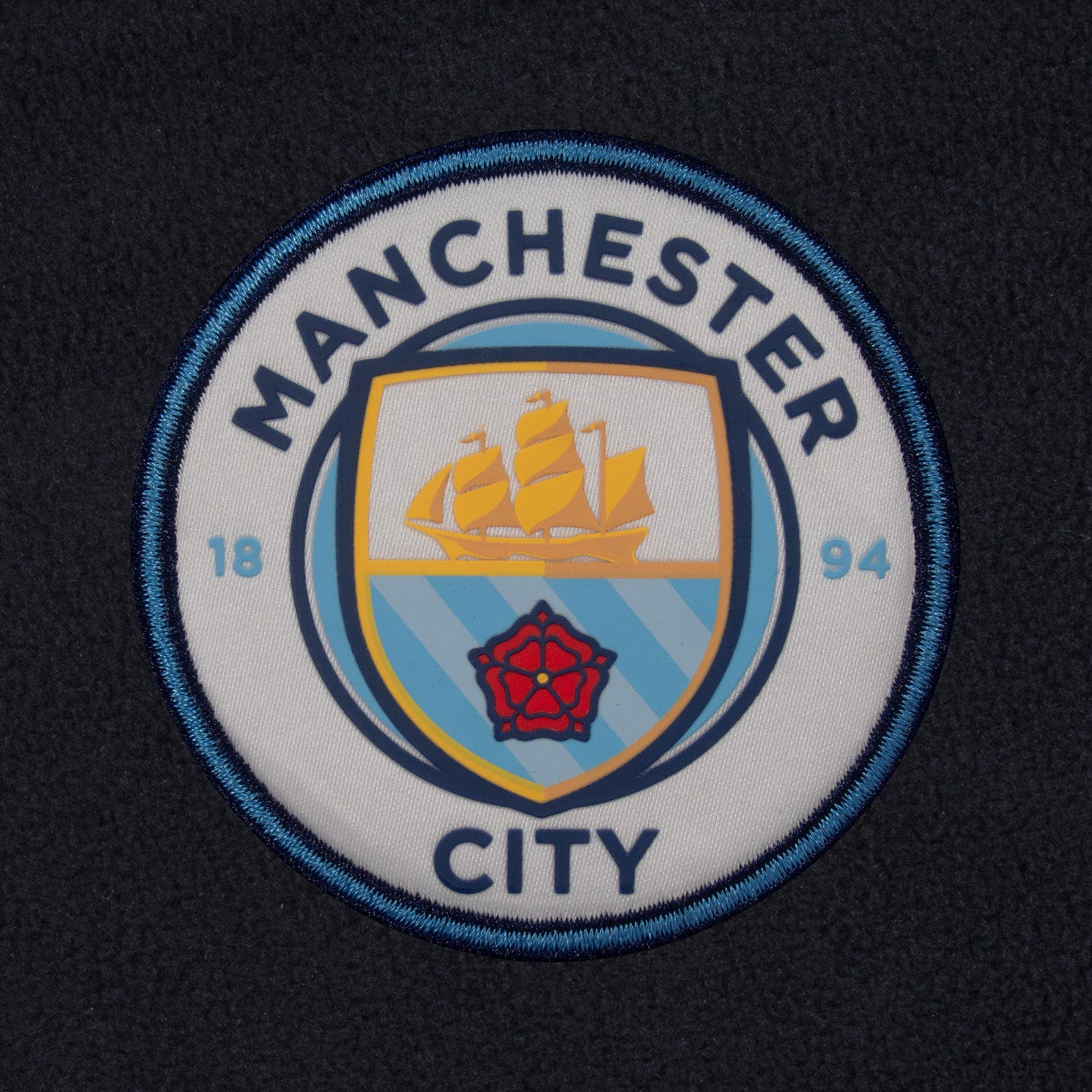 Manchester City adults microfleece jacket in navy with a woven club crest to chest.