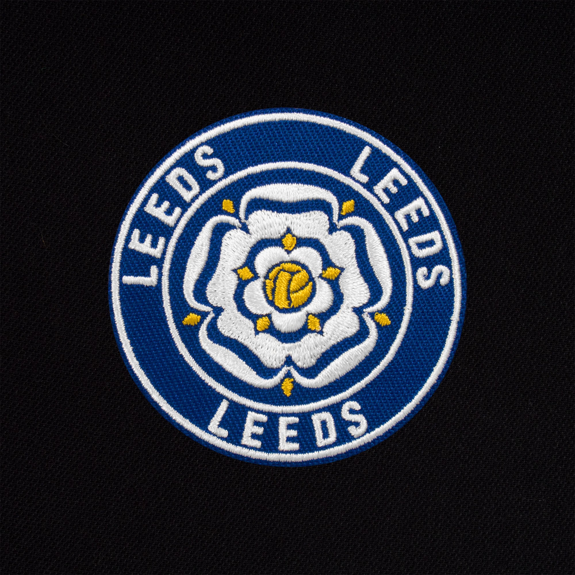 Leeds retro polo shirt in black with a rose embroidered crest applique patch to chest