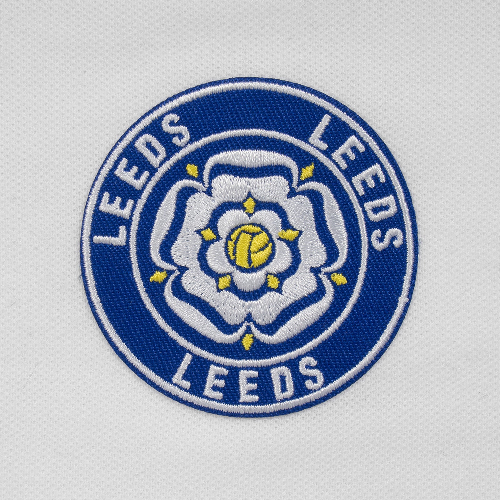Leeds retro polo shirt in white with a rose embroidered crest applique patch to chest