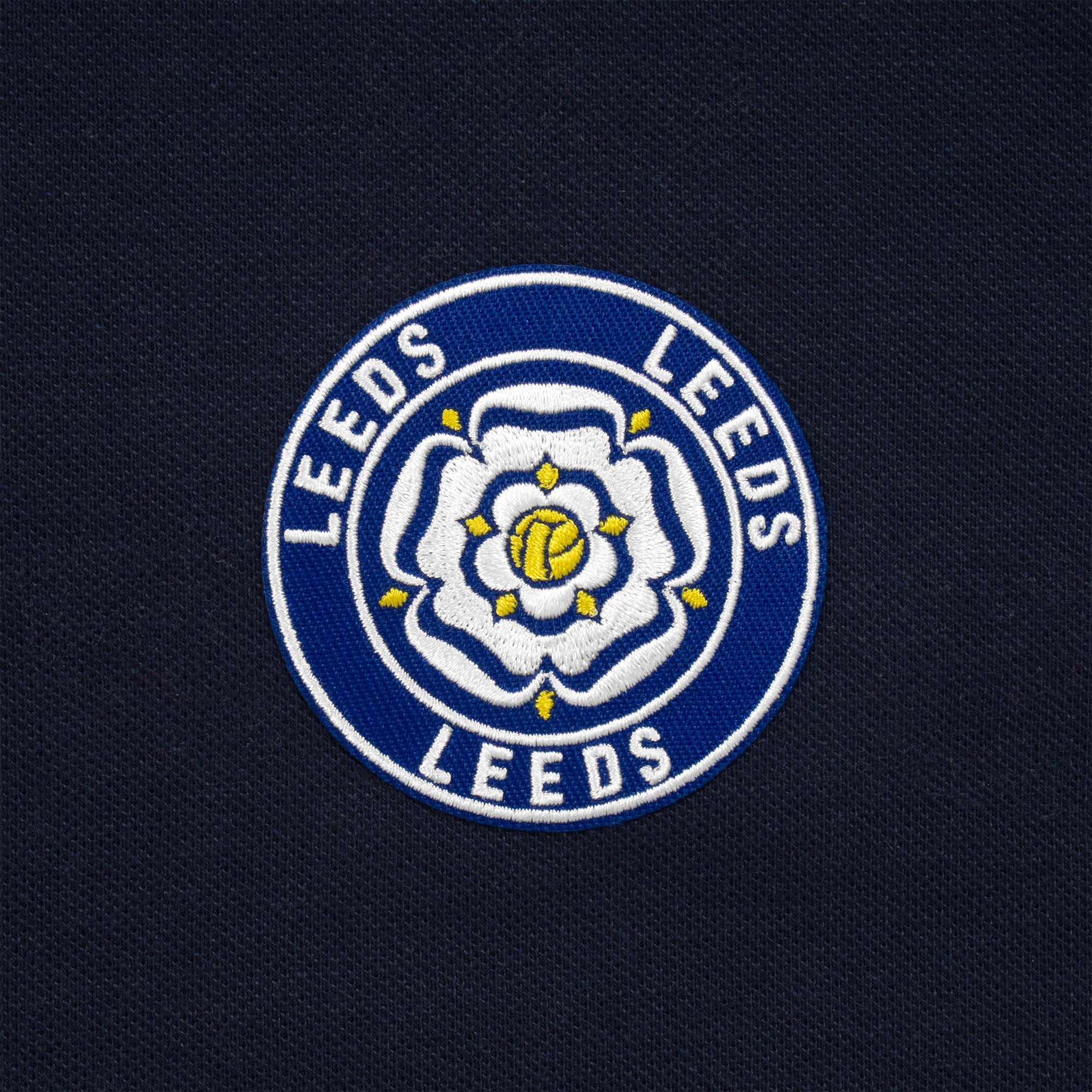 Leeds retro polo shirt in navy with a rose embroidered crest applique patch to chest
