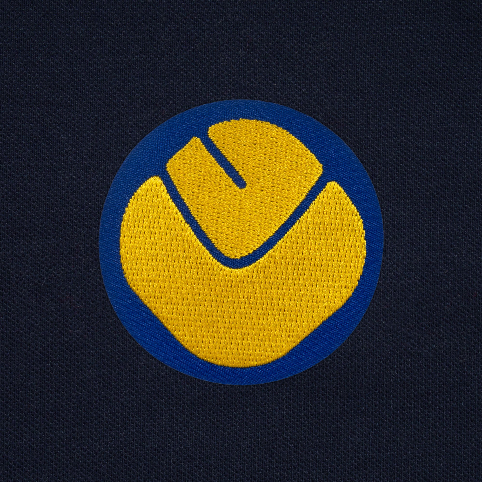 Leeds retro polo shirt in navy with a smiley embroidered crest applique patch to chest