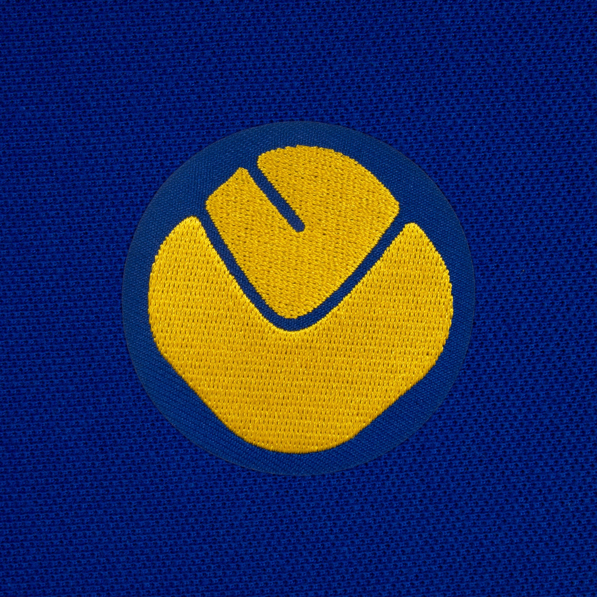 Leeds retro polo shirt in royal with a smiley embroidered crest applique patch to chest