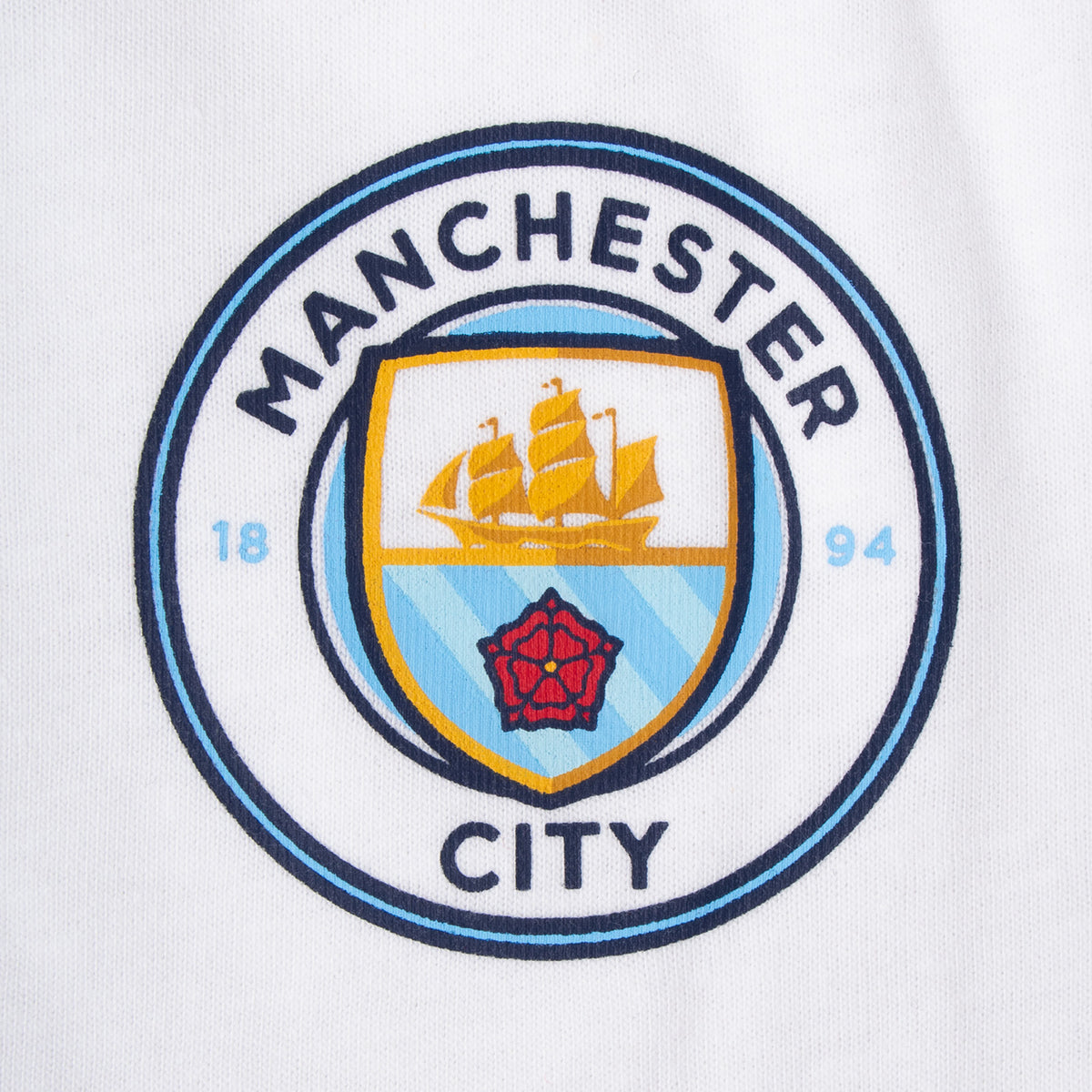 Manchester City kids loungewear pyjama set. Short sleeve t-shirt in white with Man City crest to chest. Long pants in sky blue with all-over print of the club crest