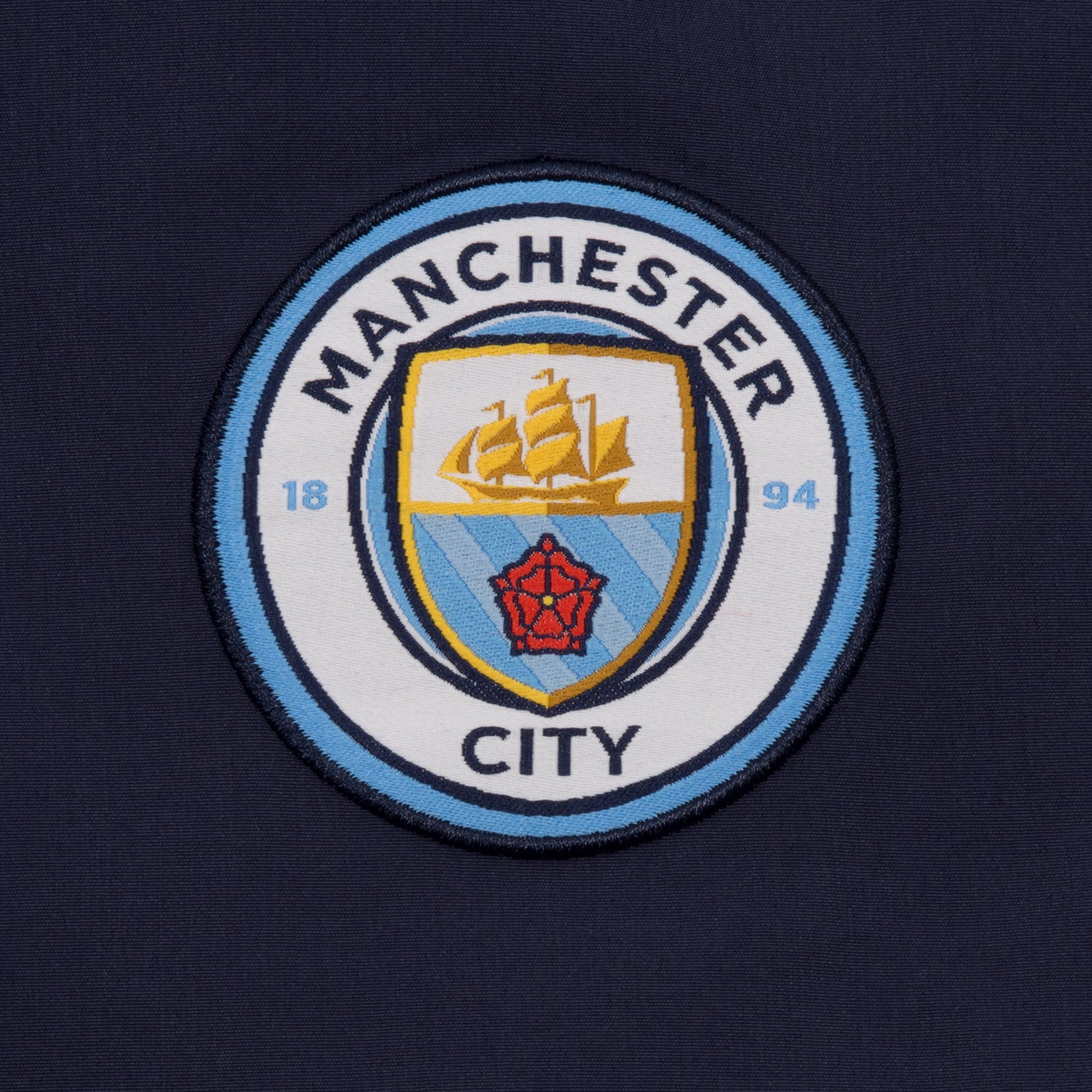 Man City adults tracksuit in navy blue with club crest to chest and left thigh