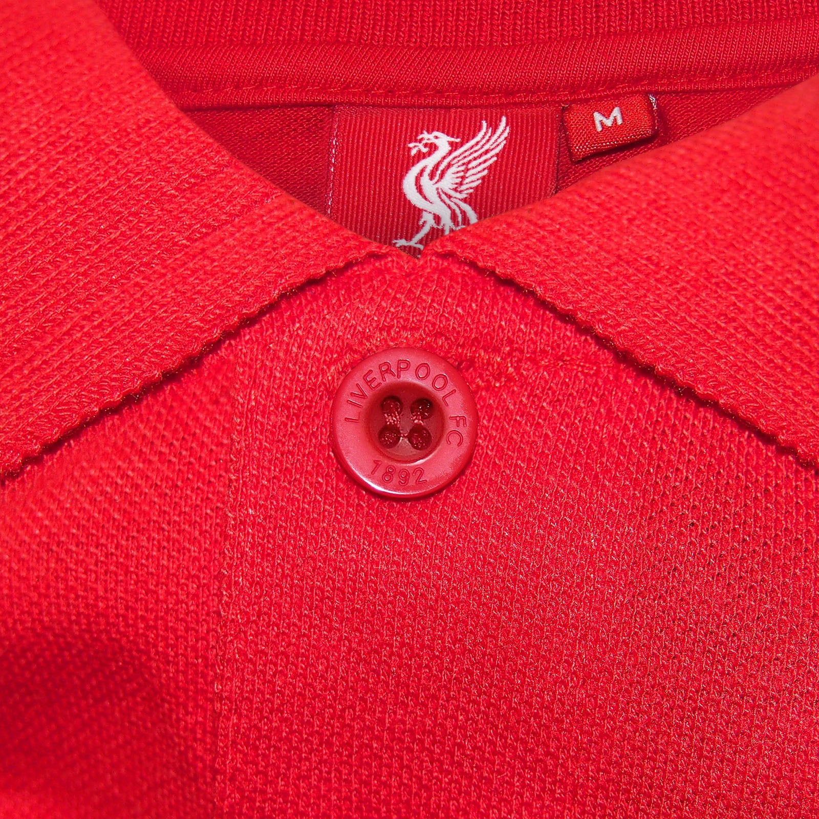 Liverpool adults polo shirt in red with LFC badge and Liverpool FC text to chest.