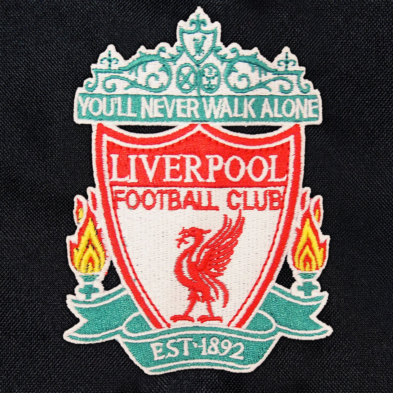 Liverpool adults shower jacket with hood in black with club crest to chest.