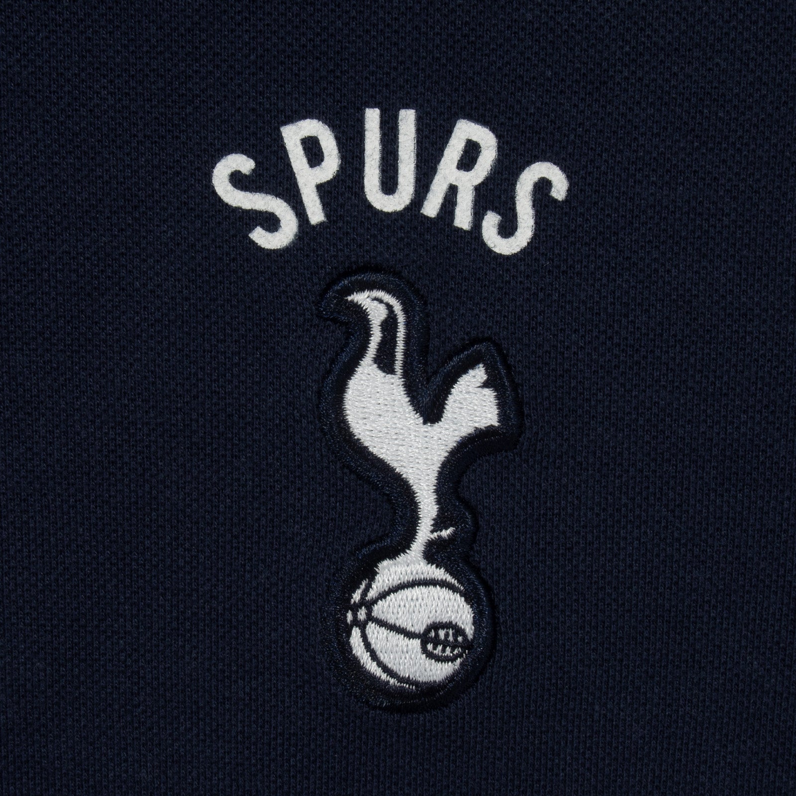 Spurs adults polo shirt in navy blue with Spurs badge and text to chest.