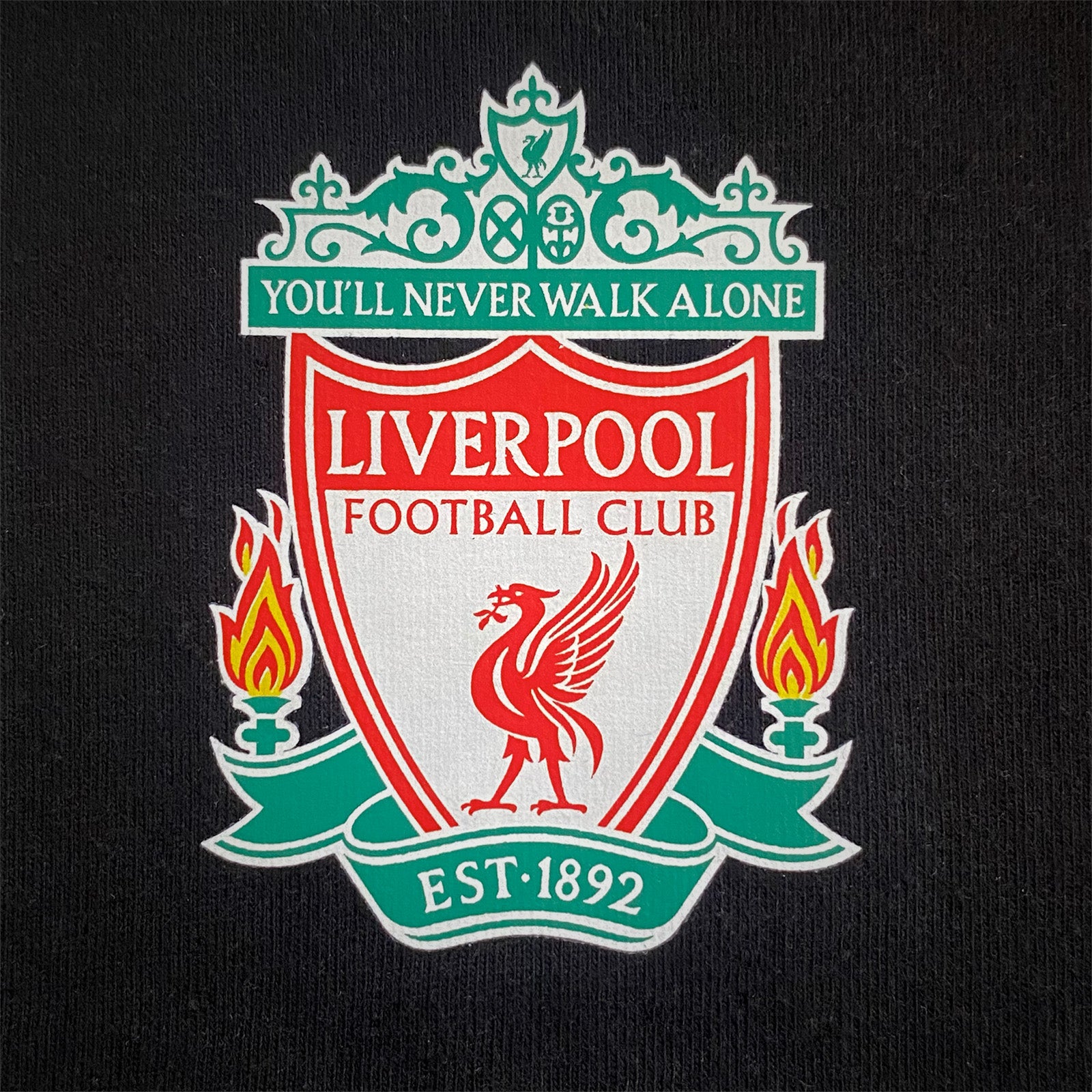 Liverpool kids pyjamas in black. Short sleeve top with graphic and shorts with logo to the left leg