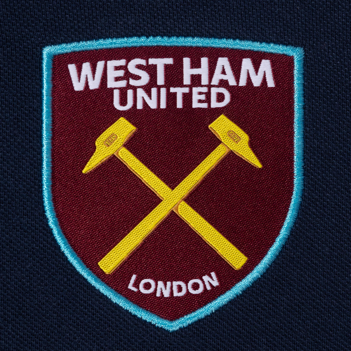 West Ham adults polo shirt in navy with WHUFC badge and text to chest.