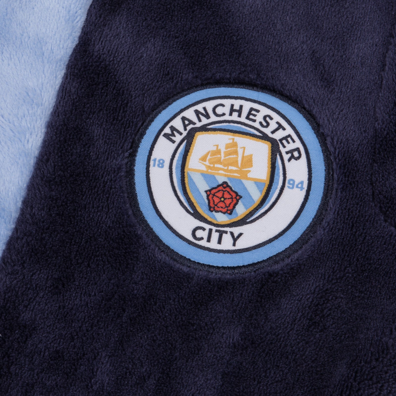 Man City kids hooded dressing gown in navy blue with crest.