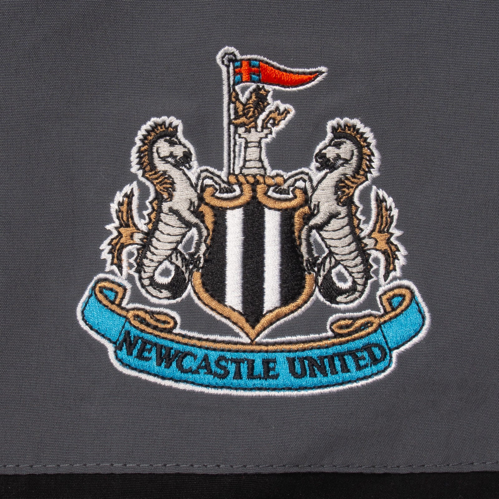 Newcastle Utd adults tracksuit in black with club crest to chest and left thigh