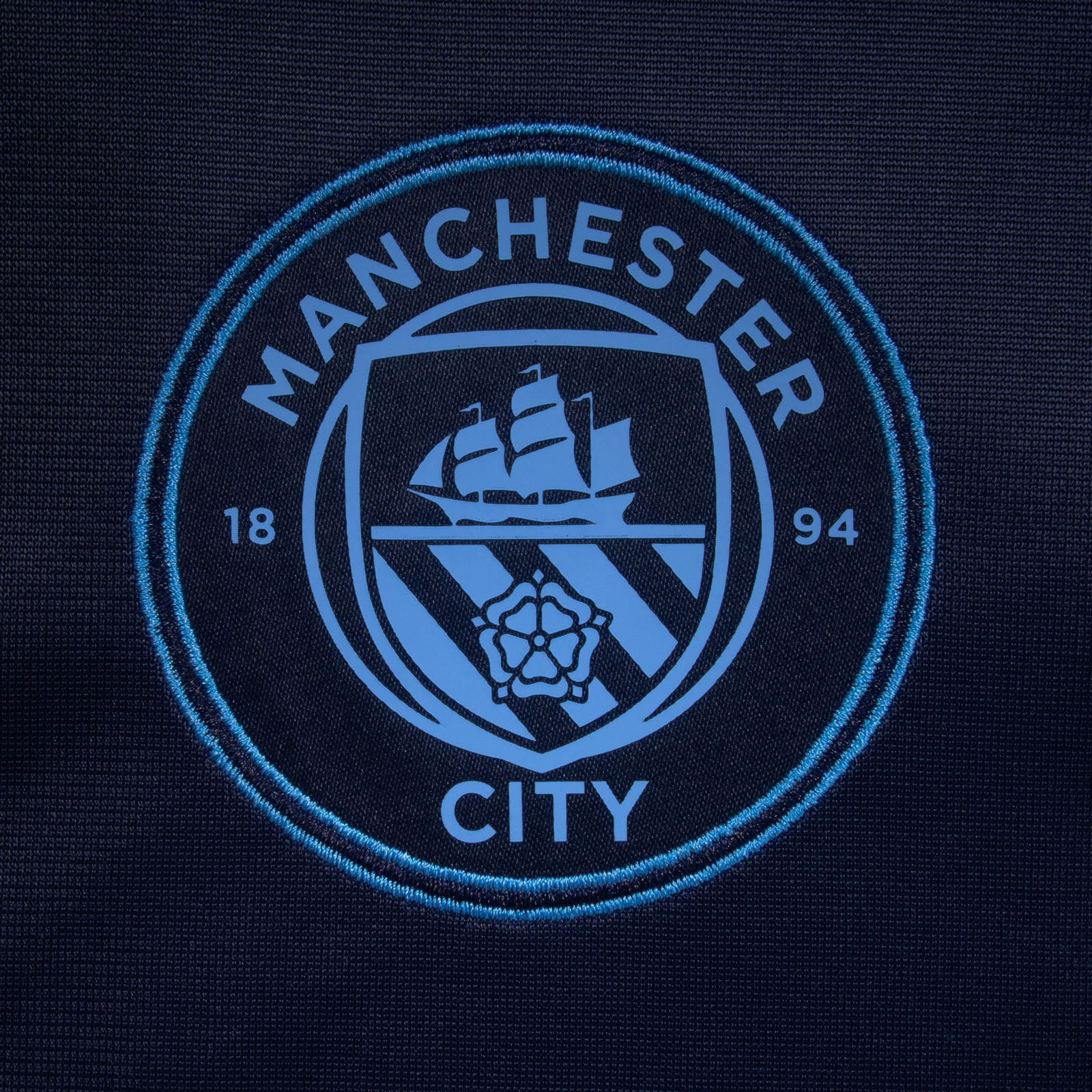 Manchester City kids taped tracksuit in navy blue with club crest and text to both top & pants