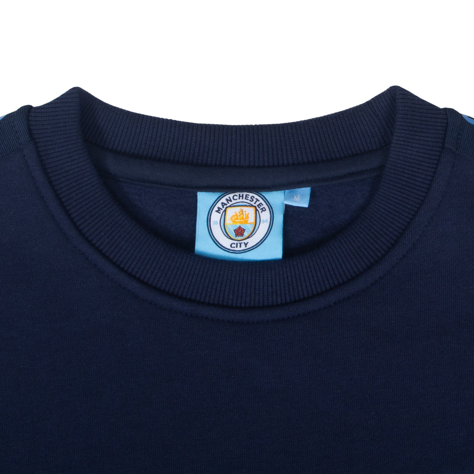 Manchester City adults taped sweatshirt in navy blue with club crest to chest and text to sleeves.