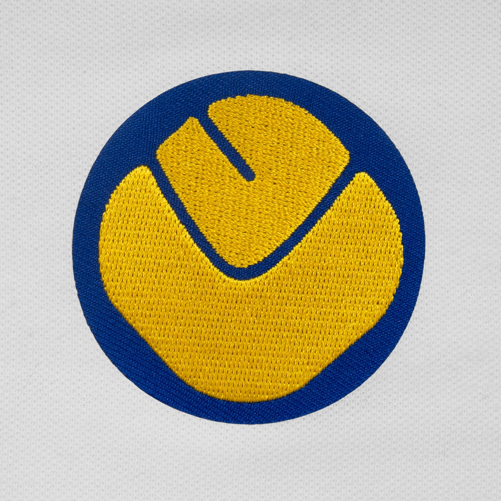 Leeds retro polo shirt in white with a smiley embroidered crest applique patch to chest